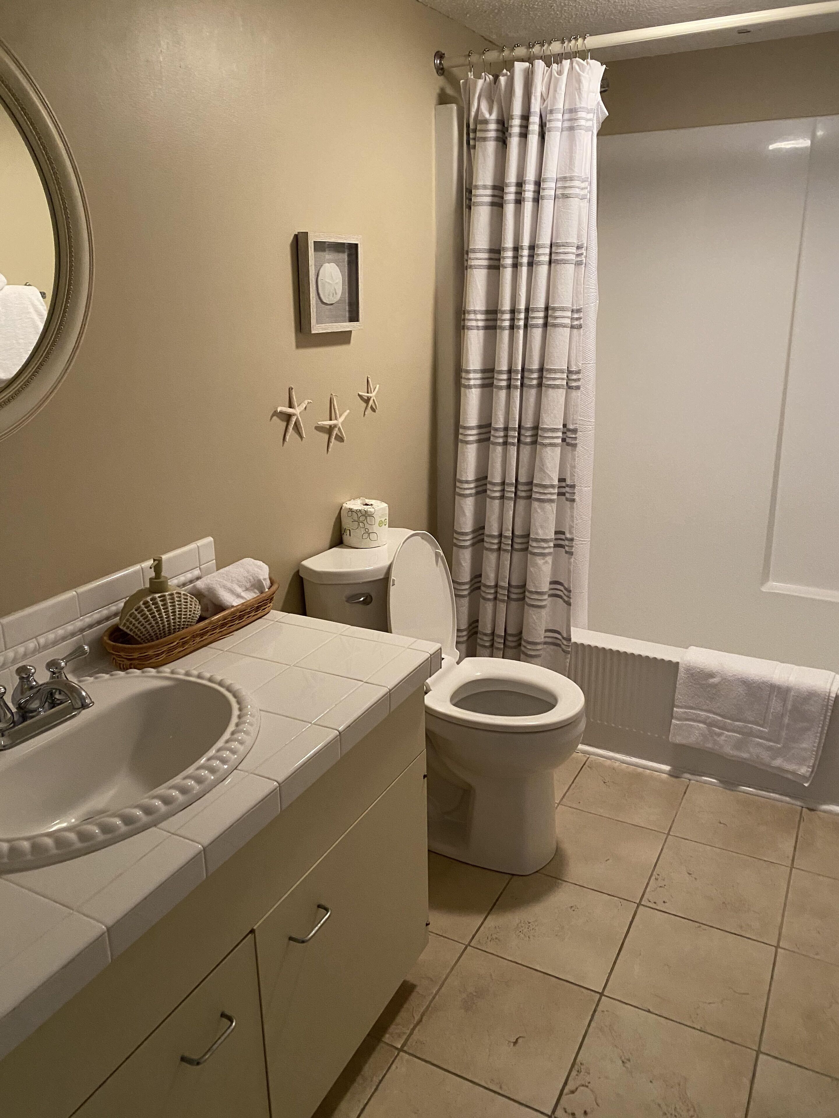 Een badkamer met een wastafel, toilet en douchegordijn.