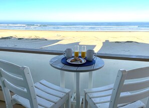 Une table dressée avec des aliments pour le petit-déjeuner et une vue sur la plage.
