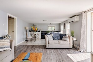 A modern living room with a sofa, coffee table, and a dining area with chairs and a table. - ✨ Lakeside Reflections (Oxford)