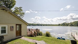 A house with a deck overlooking a lake, a pathway leading to the door, and a small boat docked near the water. - ✨ Lakeside Reflections (Oxford)
