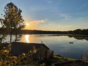 Udsigt over en sø med et hus og en anløbsbro.