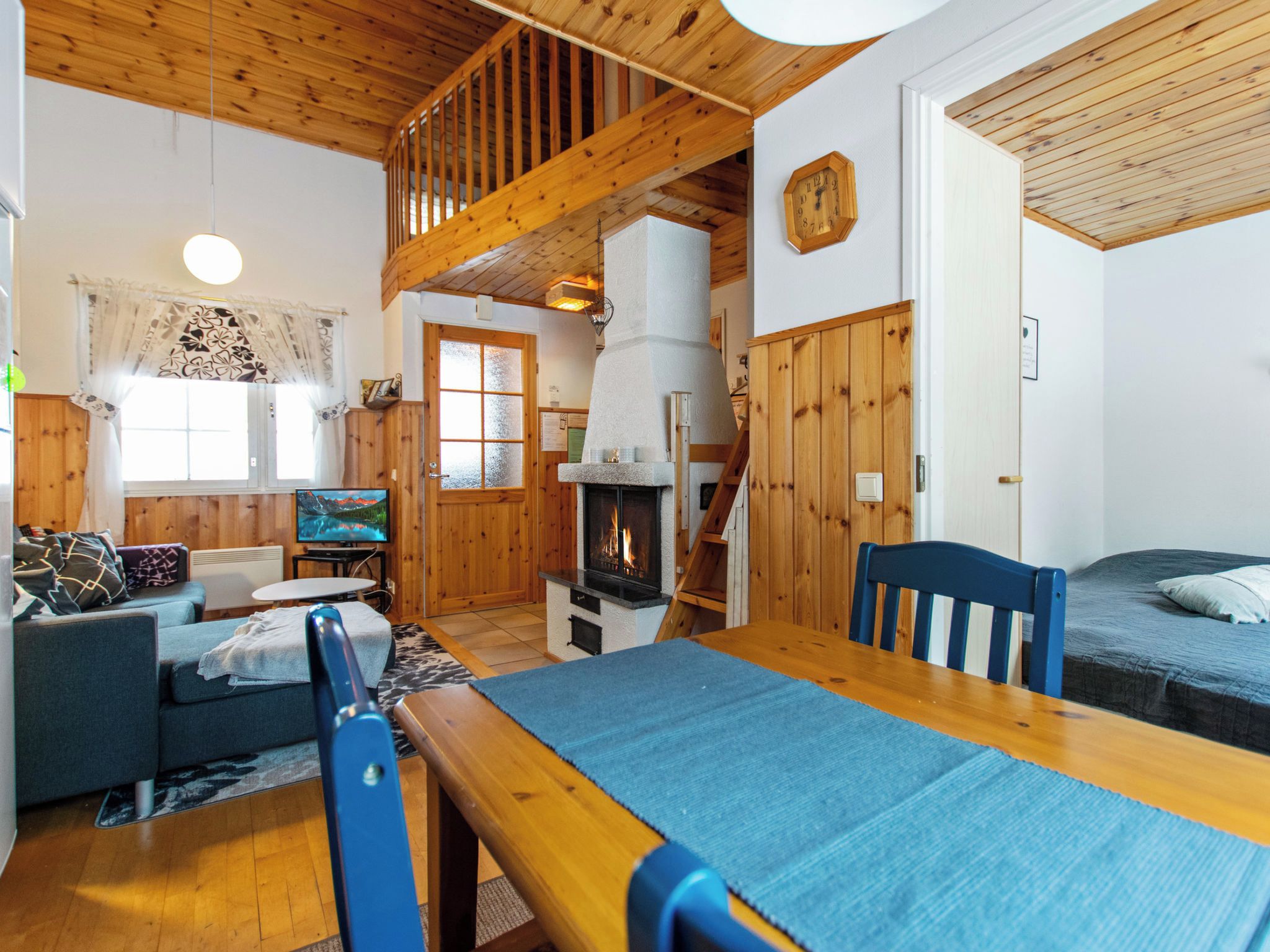 Un intérieur de chalet chaleureux avec une cheminée, des meubles en bois et un téléviseur.