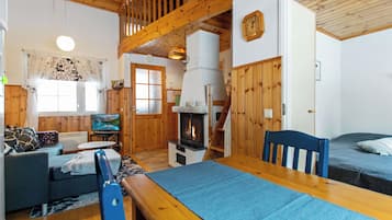 Un intérieur de chalet chaleureux avec une cheminée, des meubles en bois et un téléviseur.