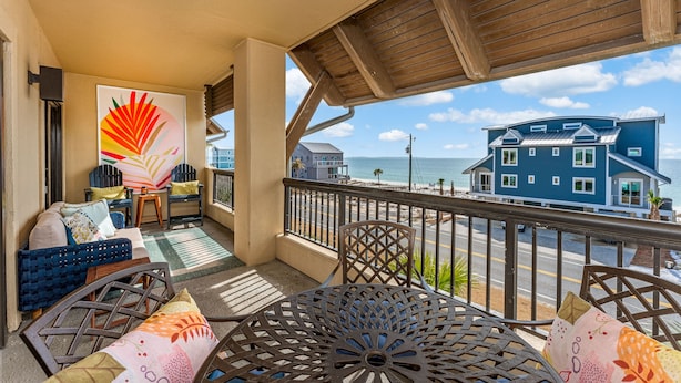 A balcony with a view of the beach and a house. - Grand Balcony Views, Pool, Hot Tub (Mexico Beach)