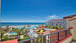 A resort with multiple swimming pools, a beach, and a view of the ocean.