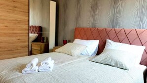 A neatly made bed with a patterned bedspread, two pillows, and two rolled towels. - Lovely 1-Bed Apartment with sea view in Srima (Srima)
