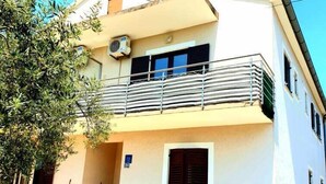A two-story building with a balcony, a satellite dish, and a small entrance with steps. - Lovely 1-Bed Apartment with sea view in Srima (Srima)