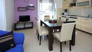 A compact living space with a dining area, kitchenette, and a TV on a stand. - Remarkable 2-Bed Apartment in Srima with sea view (Srima)