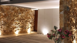 A modern building with a stone facade, large windows, and a potted plant in the foreground. - Casa BJ37 Mérida Norte, la mejor ubicación. (Mérida)