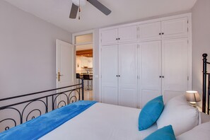 Une chambre à coucher avec un lit, une armoire, un bureau et une chaise.