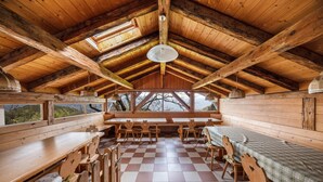 Eine Holzhütte mit Schachbrettboden, Holzbänken und Tischen.