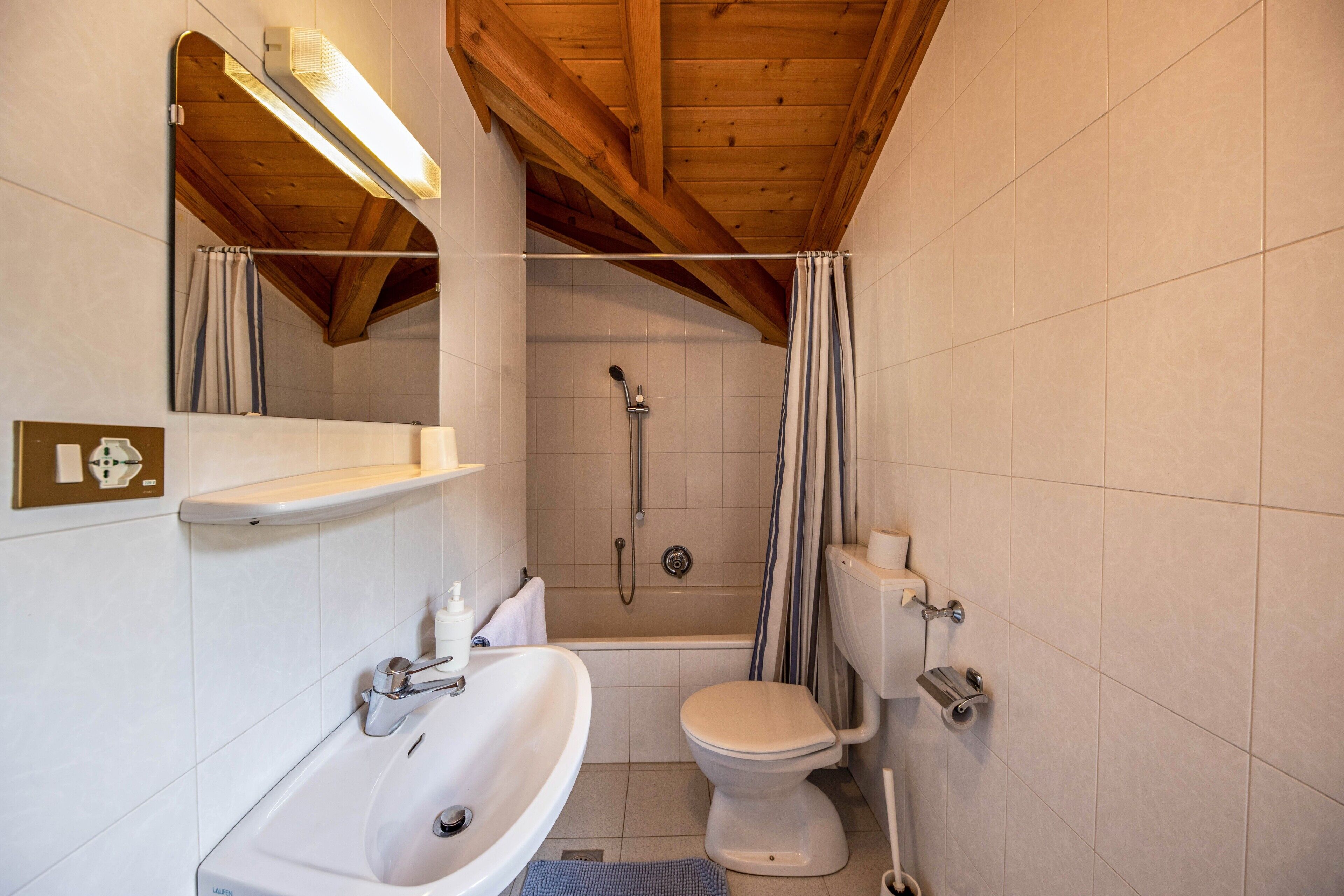 A bathroom with a bathtub, toilet, and sink.