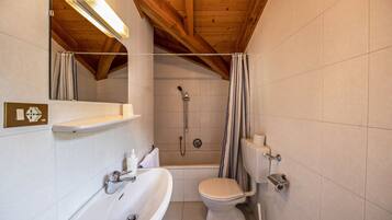 A bathroom with a bathtub, toilet, and sink.