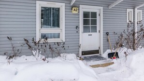 Harmaa talo, jossa on valkoinen ovi ja ovessa lukee ”A2”.