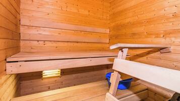 Puisesta laudelavasta ja sinisestä ämpäristä koostuva sauna.