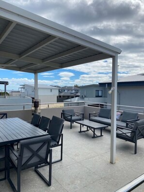 Guests can dine or relax in the covered patio area with tables and chairs.