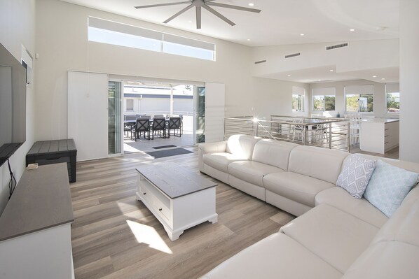 Relax in a spacious living area with a large sofa, coffee table, and sliding glass door leading to an outdoor patio.