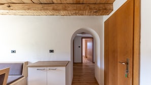 A hallway with a wooden door, a white cabinet, and a bench. - Vacation Apartment "Malgorerhof Mathilde" with Mountain View, Wi-Fi and Balcony (Jenesien)