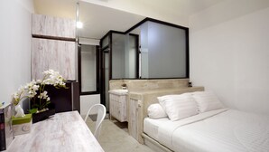 A modern bedroom with a bed, bedside table, and a mirror. - Dparagon Pogung F (Depok)