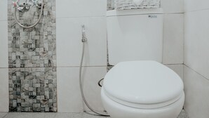 A bathroom with a shower, a toilet, and a basket of towels. - Dparagon Pogung F (Depok)