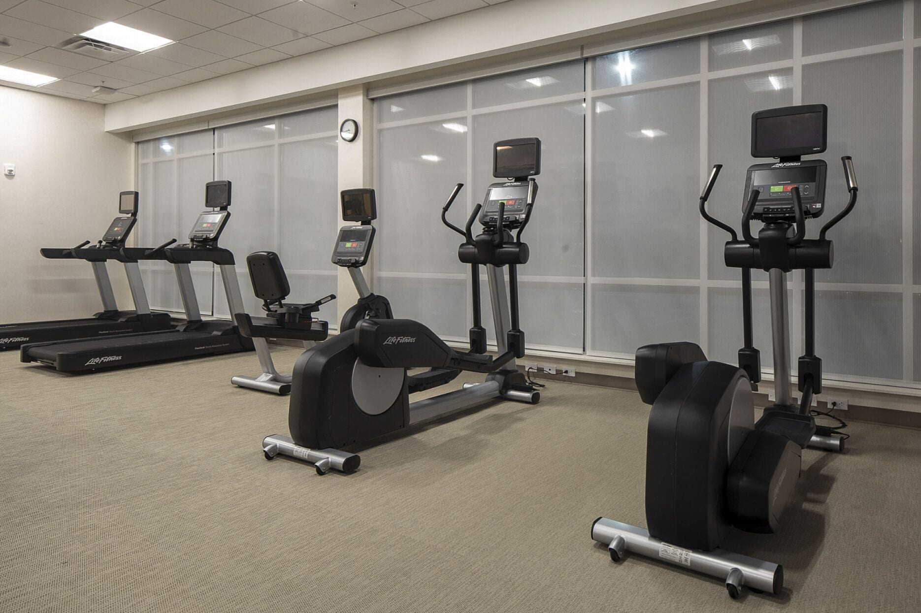 A gym with treadmills, elliptical machines, and stationary bikes.