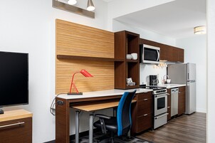 Una cocina moderna con armarios de madera, un microondas, un refrigerador y una estufa.