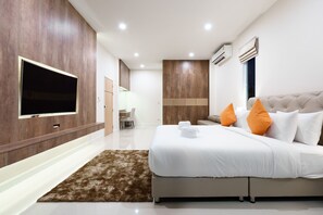 Une chambre d’hôtel moderne dotée d’un grand lit, d’un téléviseur à écran plat et d’un mur décoratif en bois.