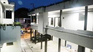 Un edificio moderno con tejado plano, ventanales grandes y un coche estacionado al frente.