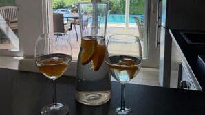 Una cocina con una copa de vino, un vaso de agua y un vaso de jugo en la encimera.