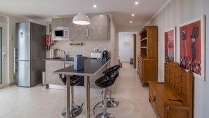 Una cocina moderna con refrigerador, microondas y taburetes de bar.