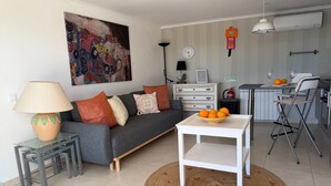 Un salon moderne avec un canapé, une table basse, une lampe et un tableau accroché au mur.