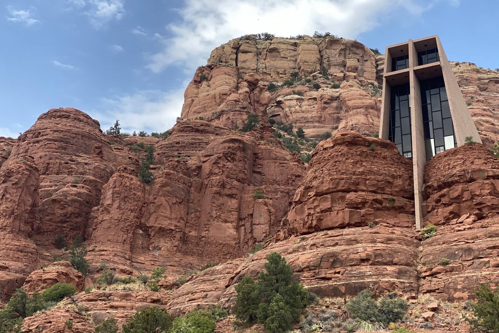 A building with a modern design, situated in a rocky landscape with prominent red rock formations.