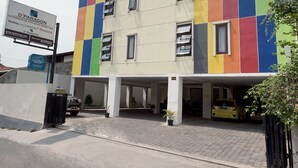 A multi-story building with a colorful facade, a parking area, and a sign for 'D'Paragon' hotel. - Dparagon Mt Haryono (Semarang)
