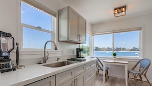 A kitchen with a large window, a coffee maker, and a blender.