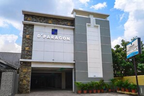 Un edificio con un cartel que dice 'D'PARAGON' y un letrero azul con texto adicional.