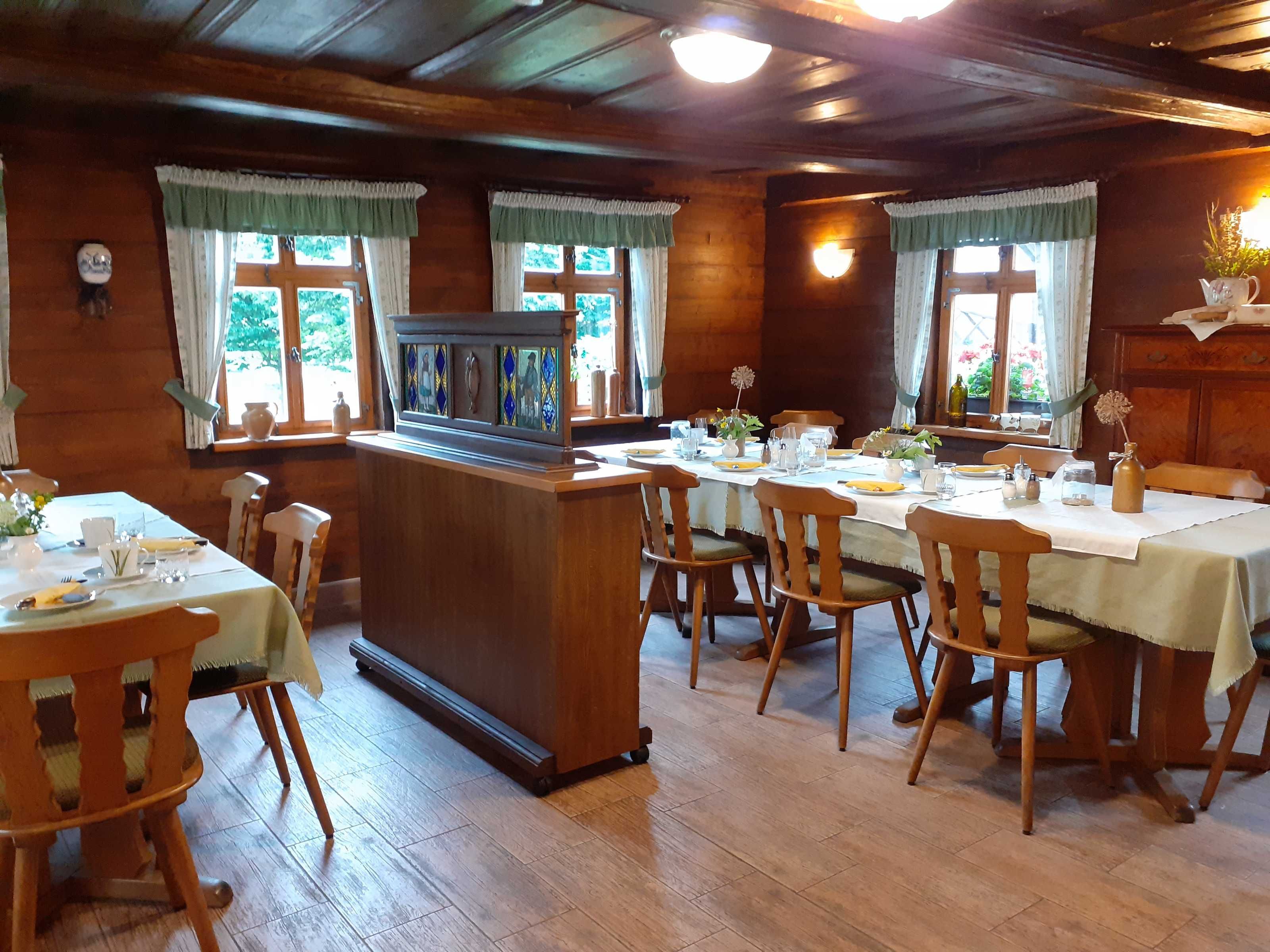 Ein Holzinterieur mit Barbereich, Esstischen und Stühlen.