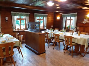 A wooden interior with a bar area, dining tables, and chairs. - EZ Gartenblick - Lavendelhof - Die Idyllische Landpension (Crimmitschau)