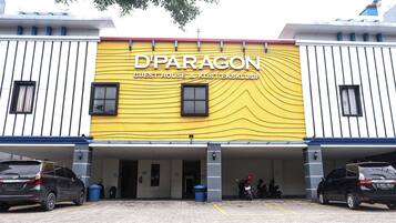Een gebouw met een gele gevel en de tekst 'D'PARAGON GUEST HOUSE & KOST EKSKLUSIF' duidelijk zichtbaar.