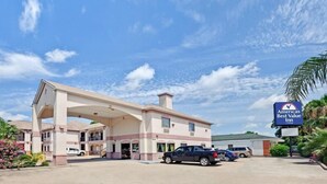 A hotel with a large parking lot, a covered entrance, and a sign indicating it is an 'America's Best Value Inn'. - Sapphire Inn & Suites- Deer Park (Deer Park)