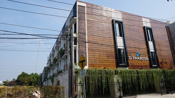 A modern building with a wooden facade and the name 'D PARAGON' on the side.