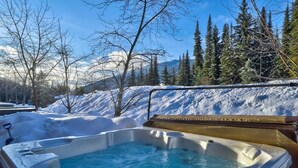 A hot tub surrounded by snow-covered landscape and trees. - Crystal Forest #29 by Bear Country (Sun Peaks)