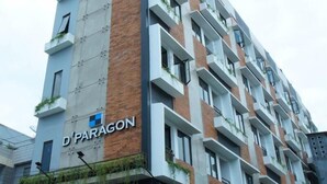 A multi-story building with a modern design, featuring a mix of brick and concrete facades, and balconies with greenery. - Dparagon Gajah Mada (Jakarta)