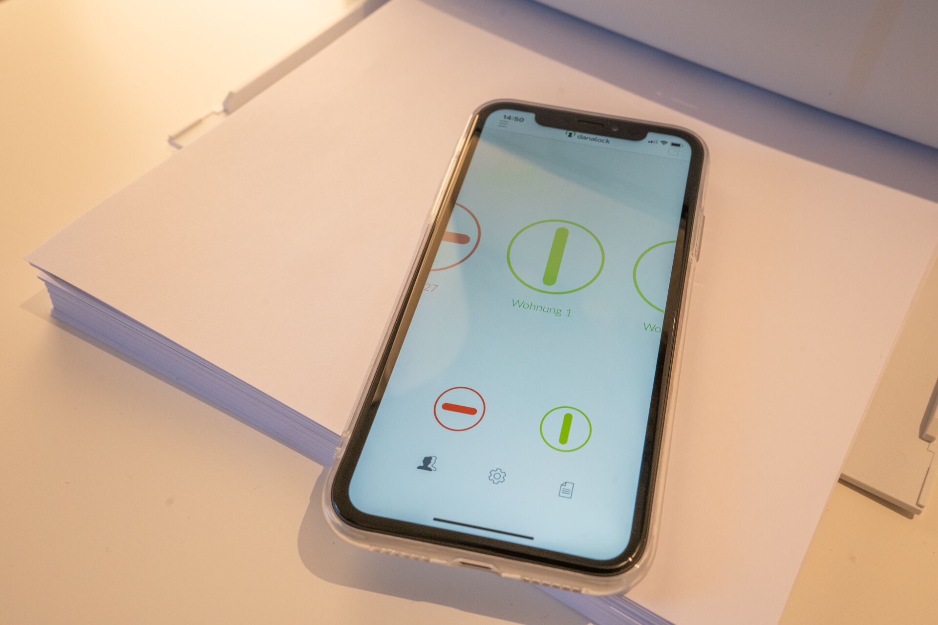 A smartphone on a white surface with a light blue screen displaying icons and text.