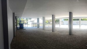 An indoor area with hexagonal tile flooring, white walls, and several columns. - Djuragan Kamar Gunung Anyar (Surabaya)