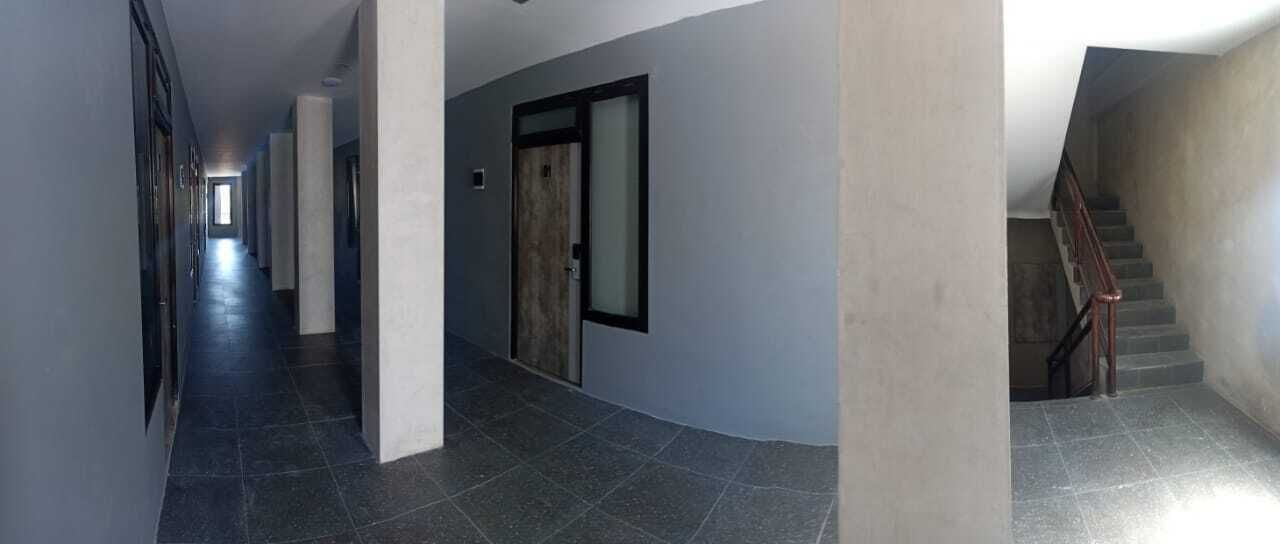 Ein langer, schmaler Flur mit Treppe auf der rechten Seite.
