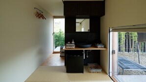 Une cuisine moderne dotée d’une grande fenêtre, d’un plan de travail noir et d’un parquet en bois.
