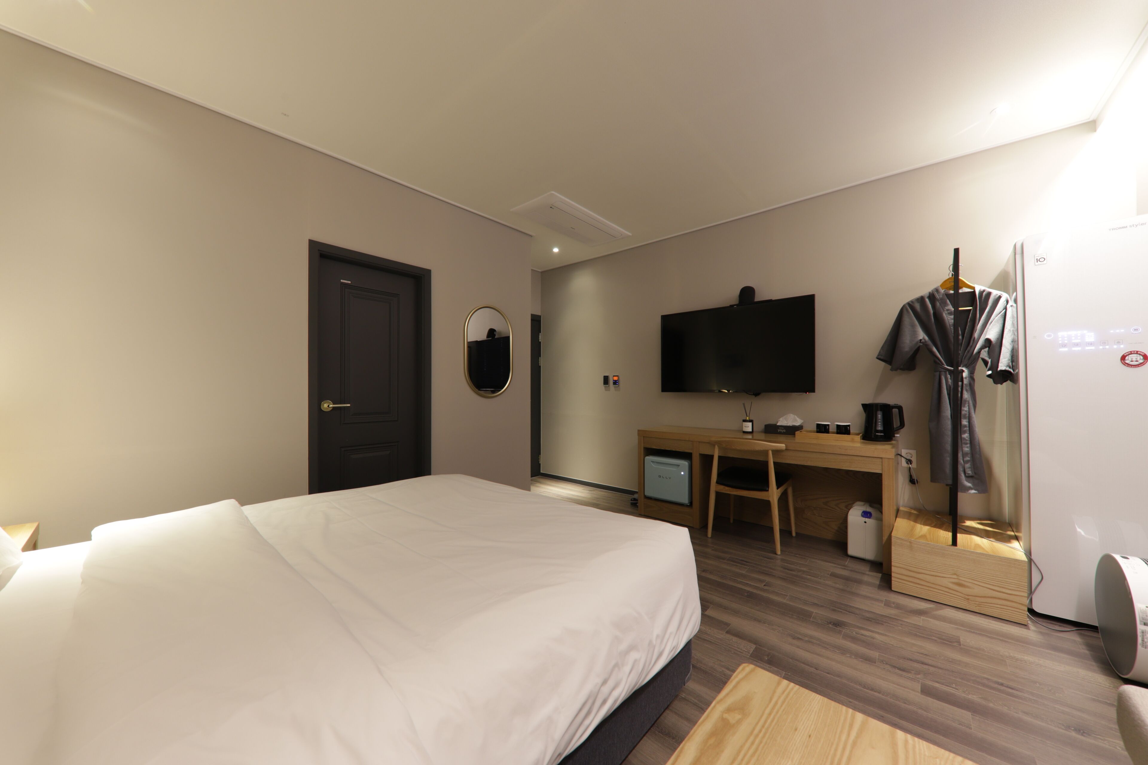 Una camera d'albergo con un letto, una scrivania, una televisione e un armadio.