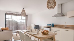 Une cuisine moderne avec un coin repas, comprenant une table en bois, des chaises et un îlot de cuisine.