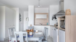 A compact kitchen with white cabinets, a wooden countertop, a microwave, and a coffee machine. - 50m from the beach, seaview flat for 2 (Pléneuf-Val-André)