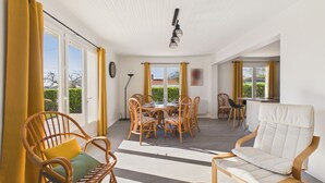 A spacious room with a dining table, chairs, and a sofa. - Holiday home for 6 in Saint Hilaire de Riez (Saint-Hilaire-de-Riez)